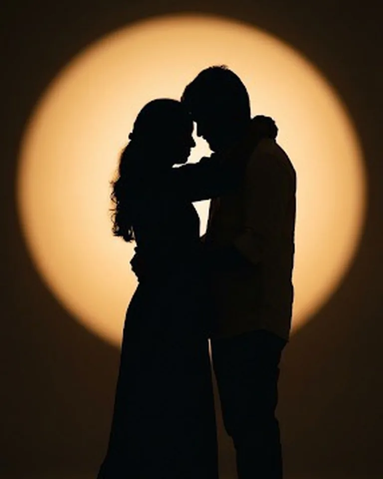 Silhouette of the couple against a golden circle of light